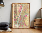 A framed vintage map of New York City, depicting the city's streets, neighborhoods, and surrounding areas.