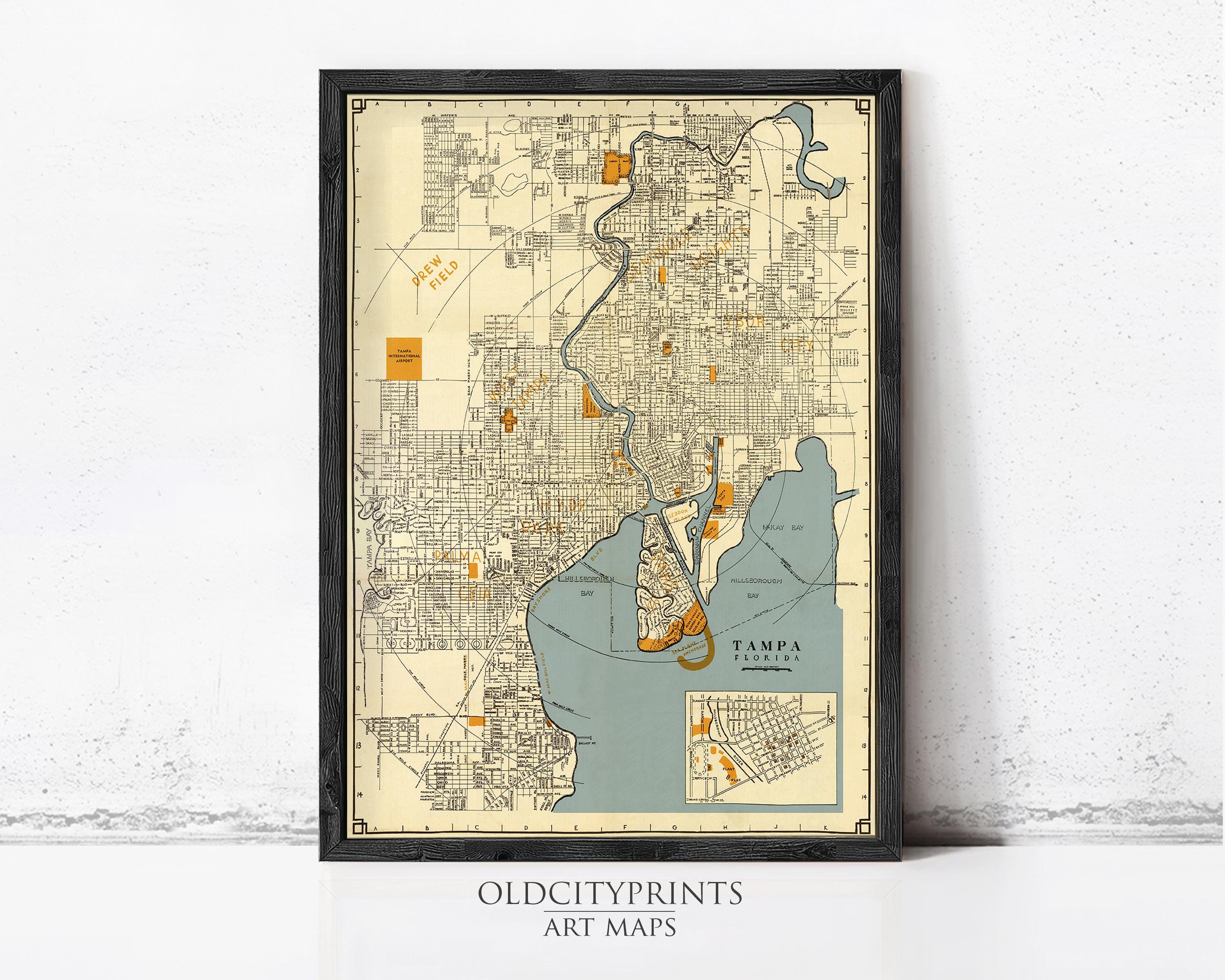 The image is a framed vintage map of Tampa, Florida, depicting the city's streets, landmarks, and surrounding areas.