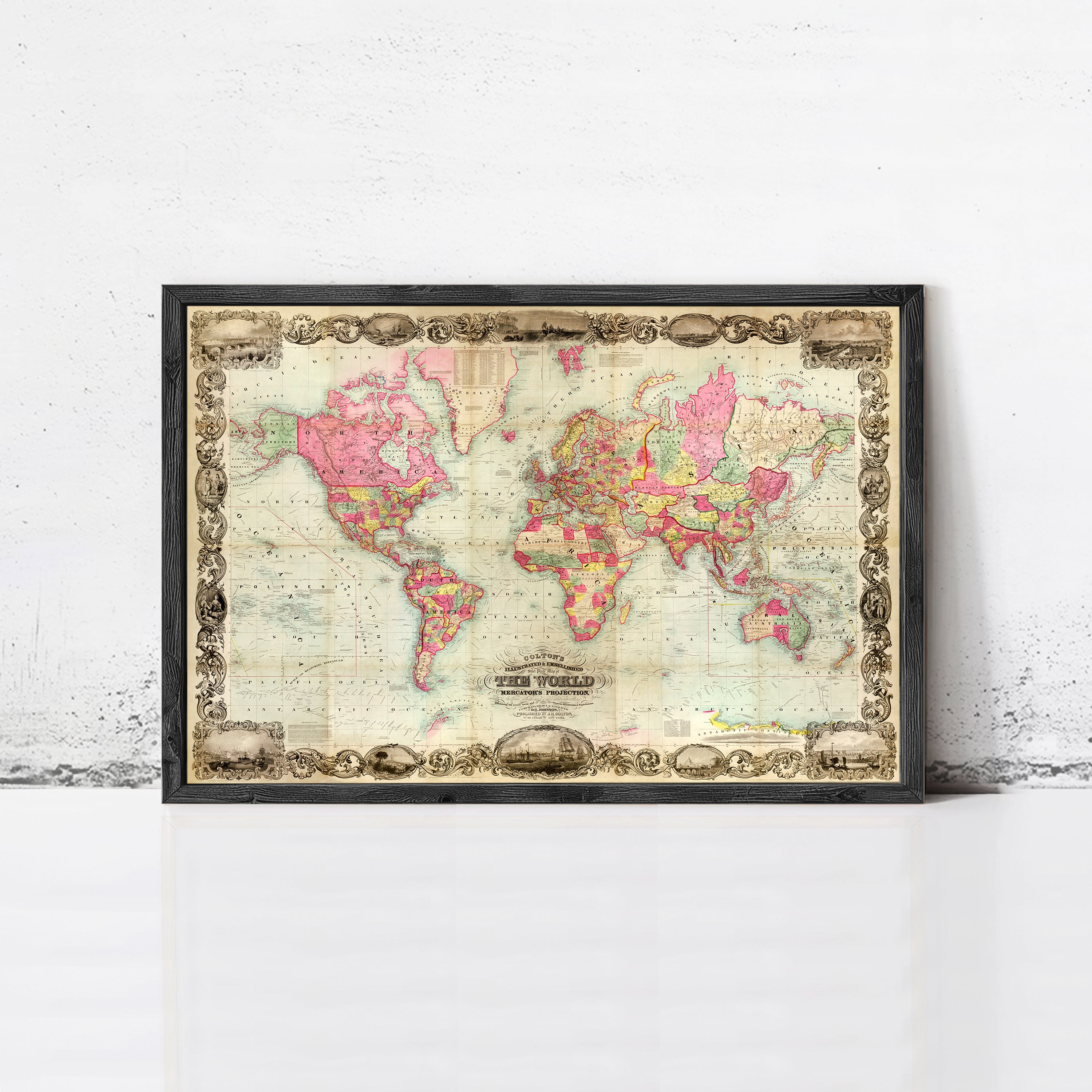 The image is a framed vintage world map with a decorative border, displayed on a white wall.