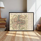 A framed map of the city of Berne, France, displayed on a wooden floor in a room with a lamp and books.