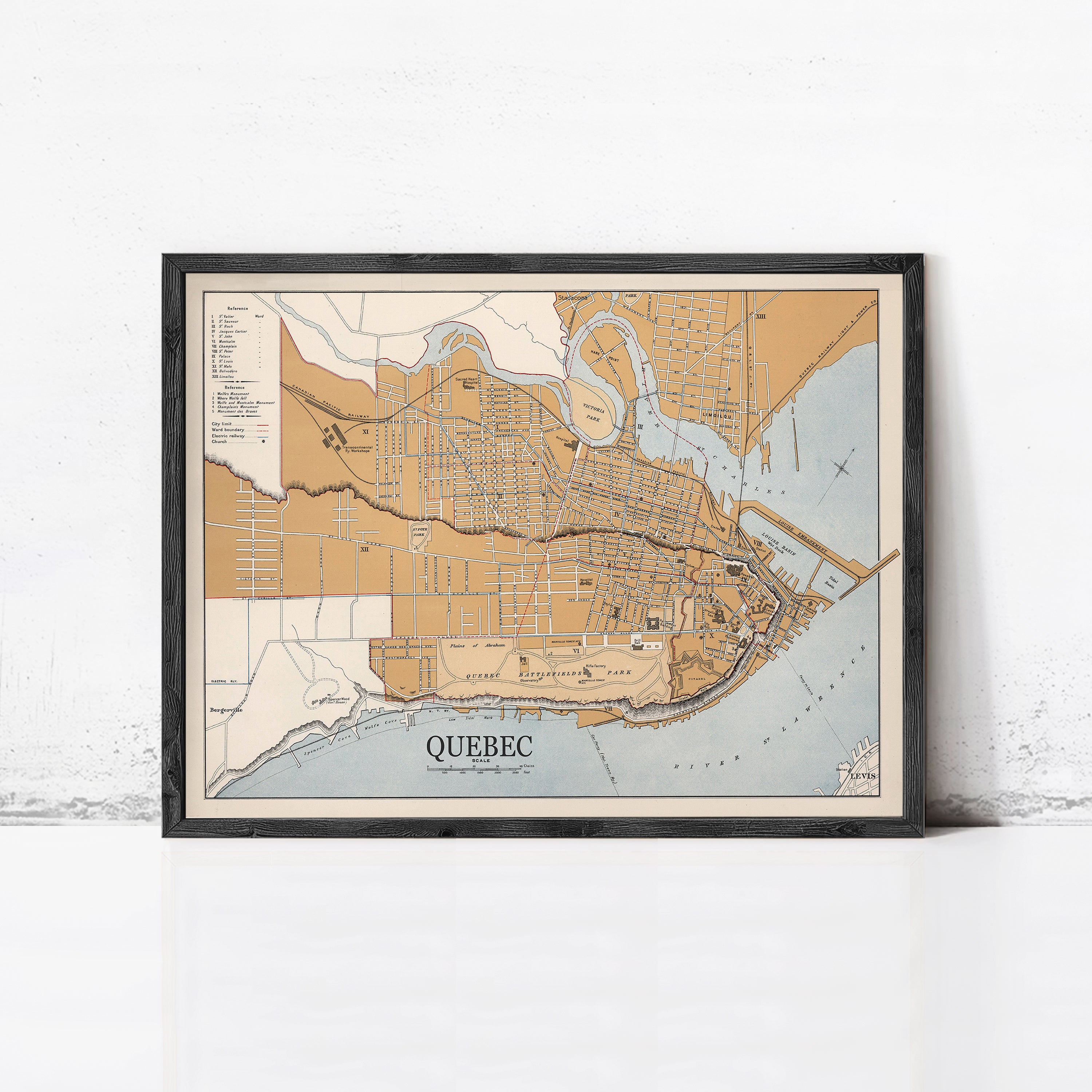 The image is a framed map of Quebec, Canada, depicting the city's streets, rivers, and surrounding areas.