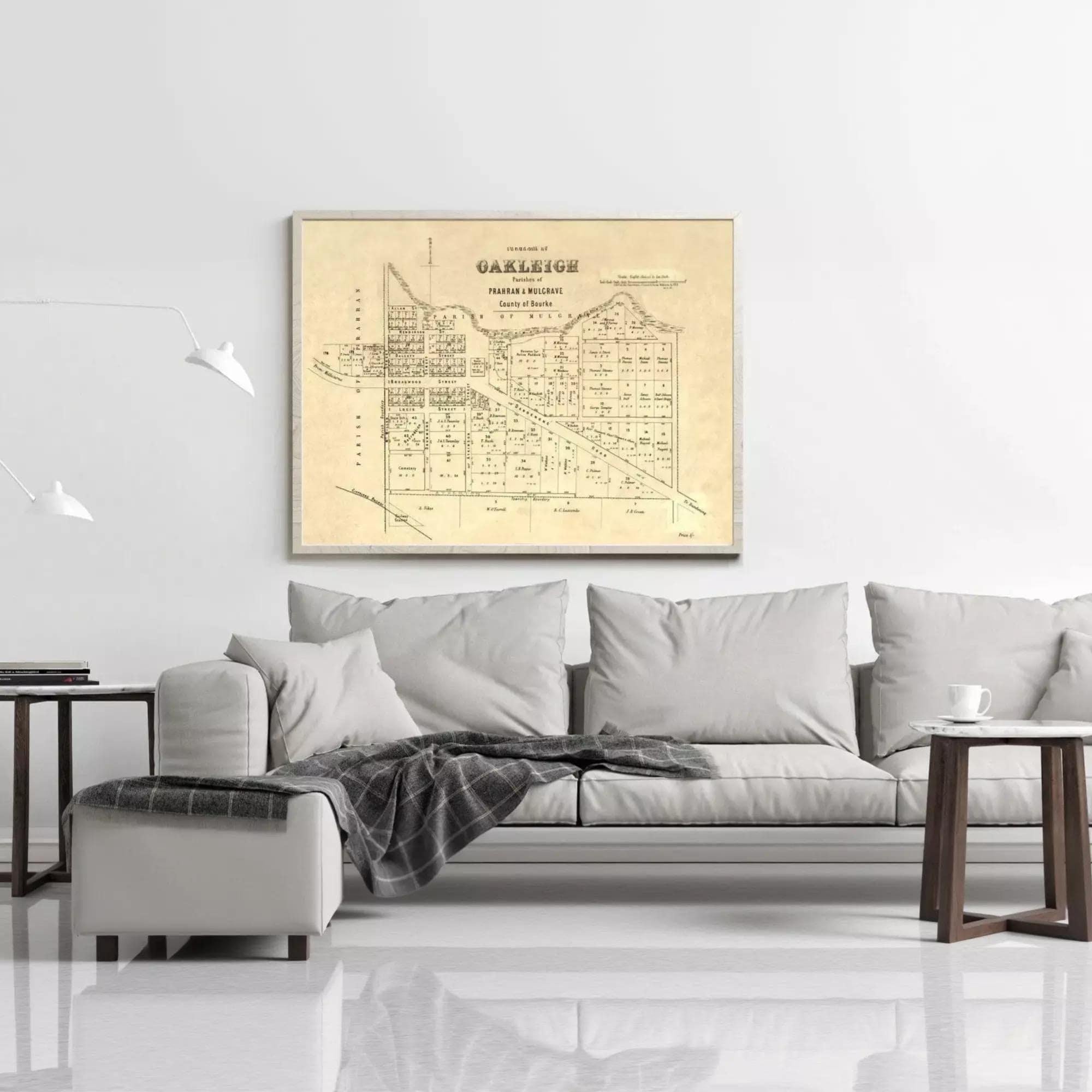a living room with a large framed map of Oakleigh on the wall above a gray sofa.