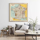 a large framed map of France hanging on a wall above a couch in a living room setting.