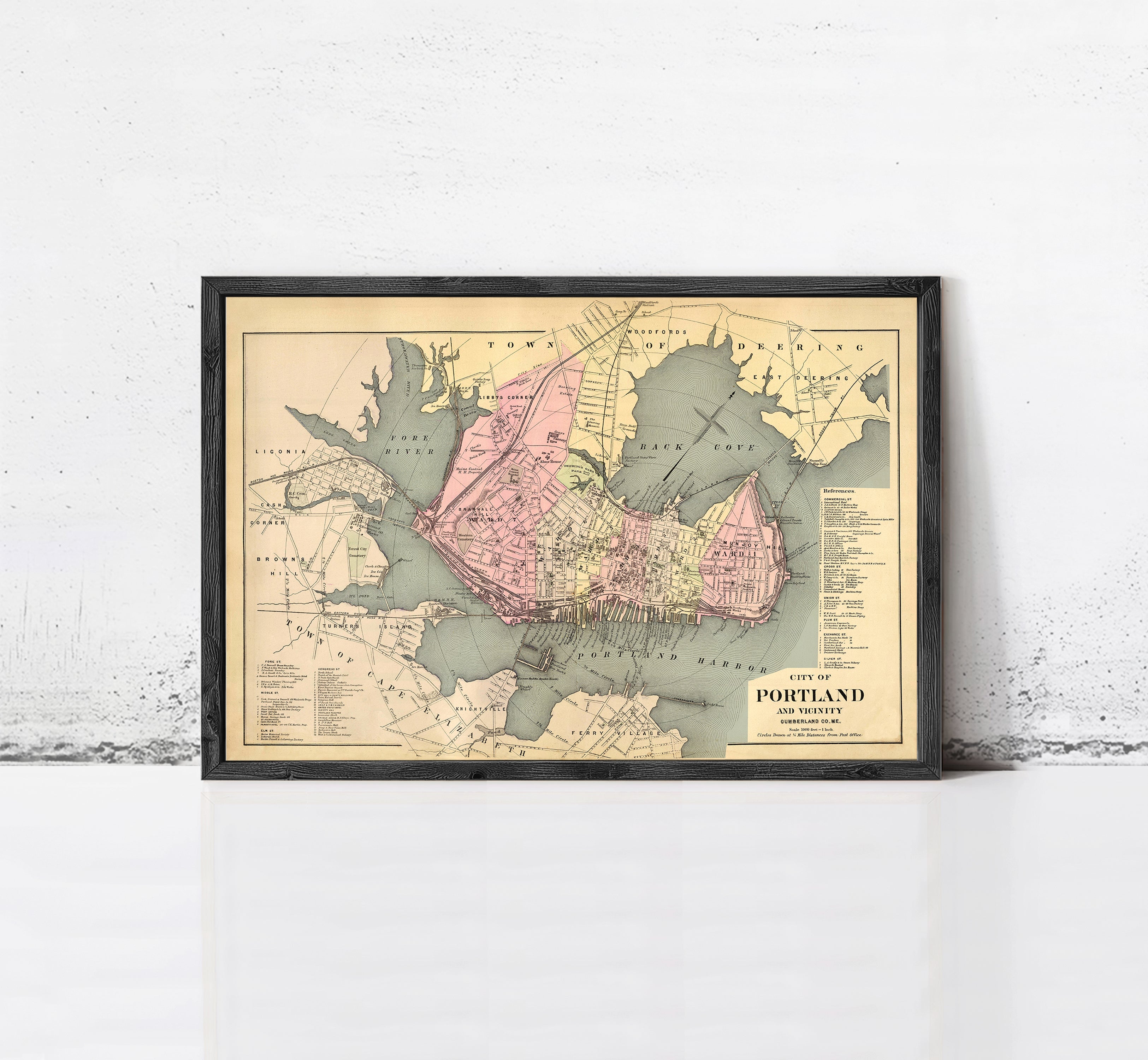 The image is a framed vintage map of Portland, Oregon, depicting the city's layout and surrounding areas.