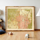 a large framed map of a city, with a wooden floor and a few small figurines in the foreground.