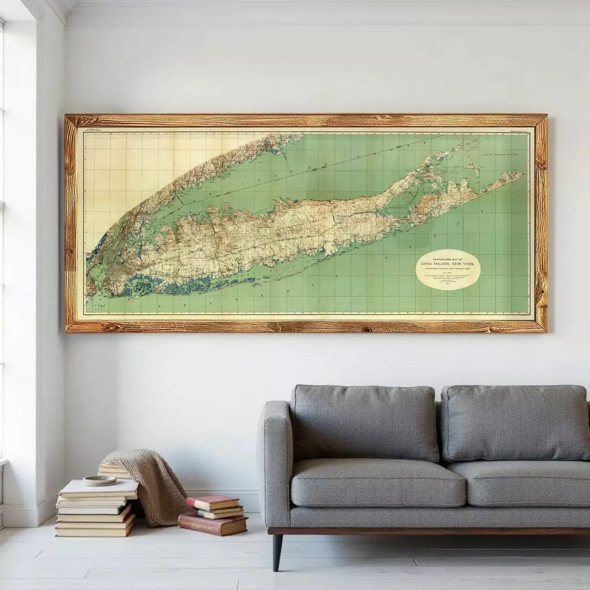 a large framed map of the United States, specifically the state of New York, hanging on a wall above a gray couch in a living room.