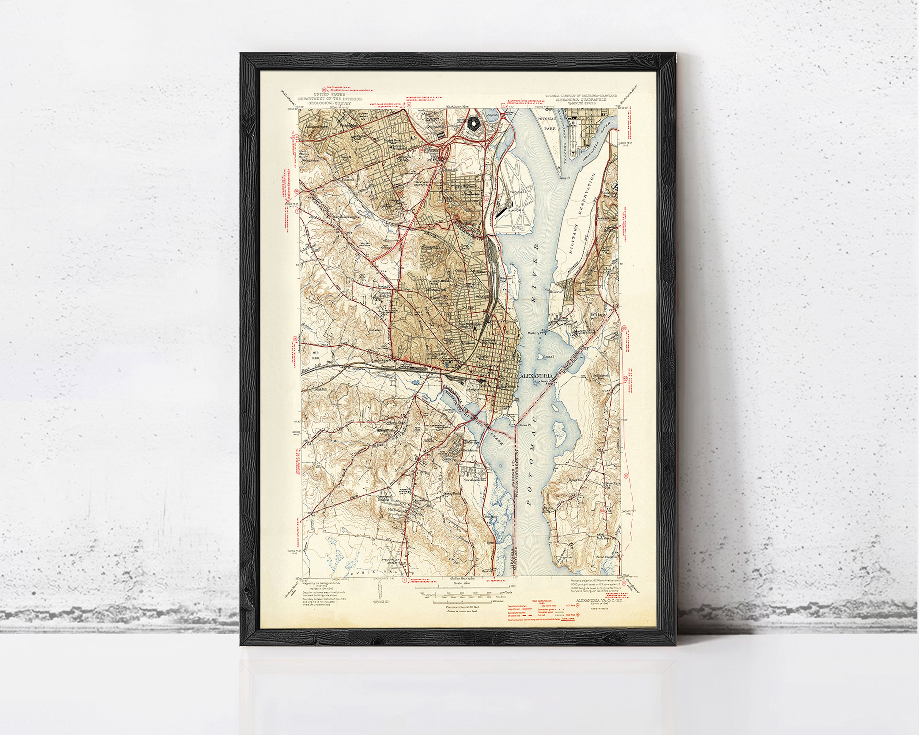 The image is a framed vintage map of the Washington, D.C. area, depicting the city's streets, waterways, and surrounding landscape.