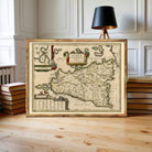 a framed map of Sicily, Italy, with a black lamp in the background.