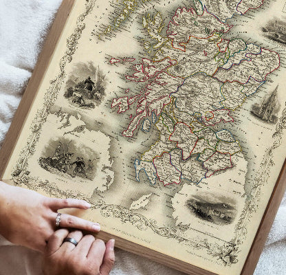 Vintage map book with a person's hands holding it open
